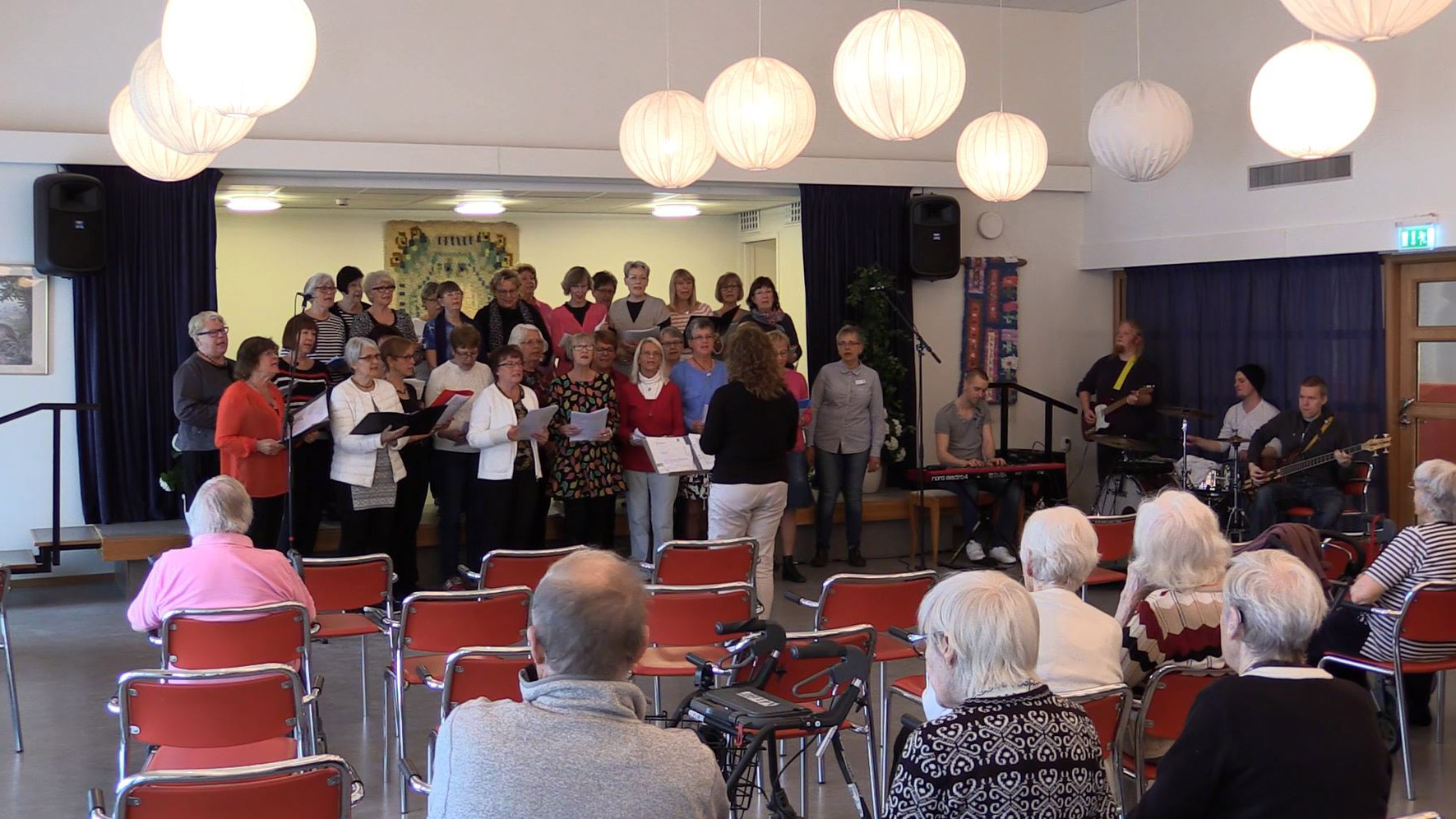 Seniorkör sjunger för publik.