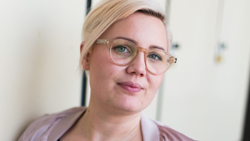 Närbild på en blond kvinna med glasögon