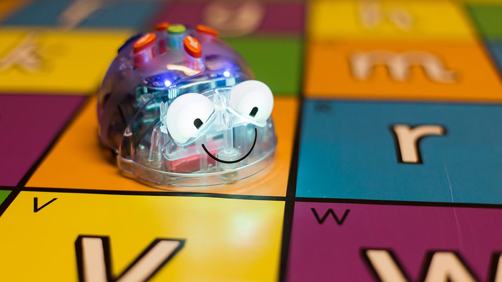 En gullig robot som är på ett spelbräde med bokstäver