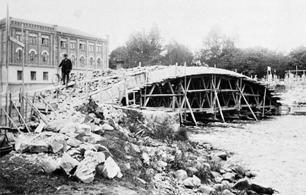 Drottningbron under byggnation, med Rådhuset i bakgrunden. Fotat från andra sidan ån