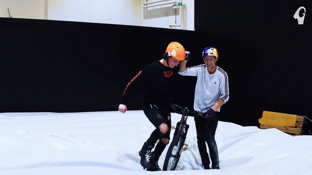 Två män stående i landningen av ett cykelhopp på extremsportarenan Dome.