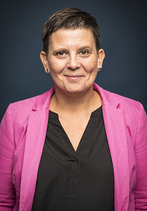 Porträttfoto i studio på Kajsa Svaleryd i rosa kavaj och som ler mot kameran.