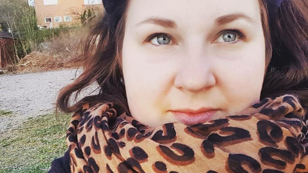 Närbild på en mörkhårig kvinna med en leopardscarf