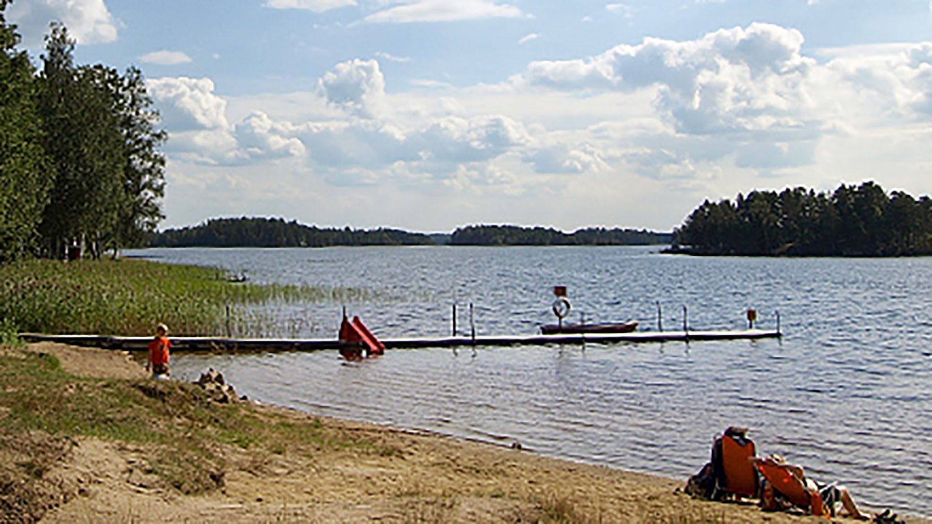 Vatten, brygga och sandstrand vid Högbacka