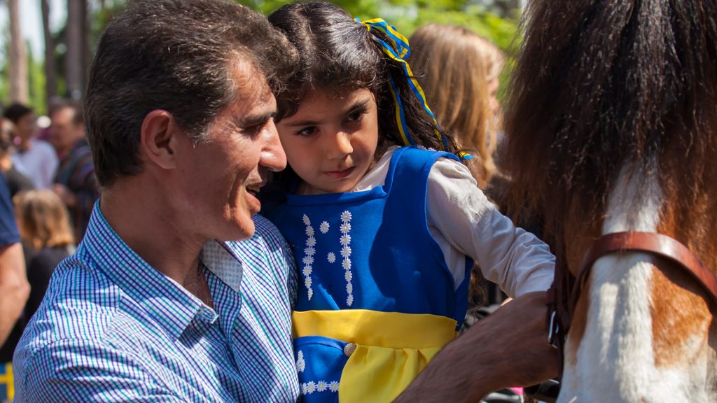 En pappa och dotter i sverigeklänning på nationaldagen