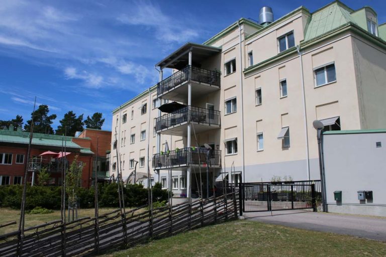 Exteriör bild på huset med gärdesgård.