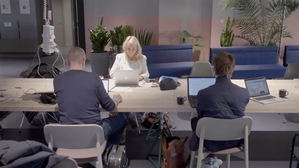 Tre personer som sitter vid ett skrivbord