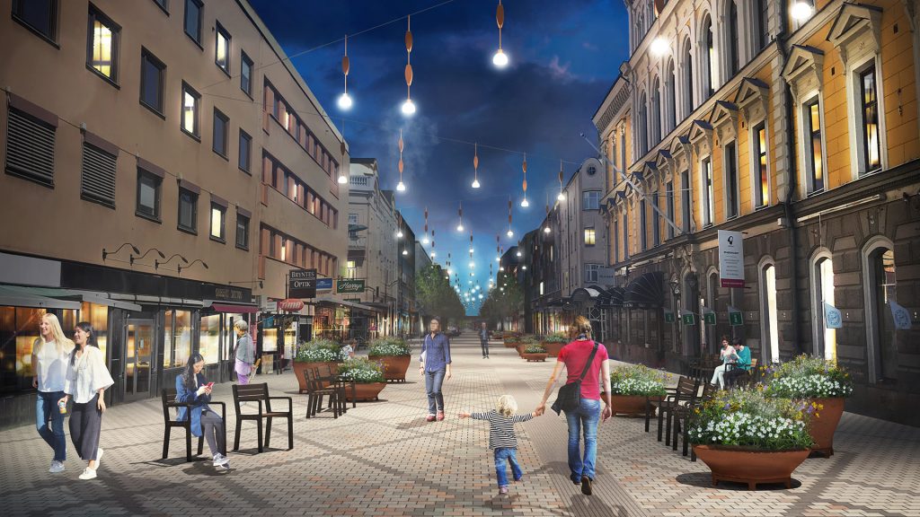 Kvällsvy över Drottninggatan med nya bänkar, blomsterurnor och lampor.