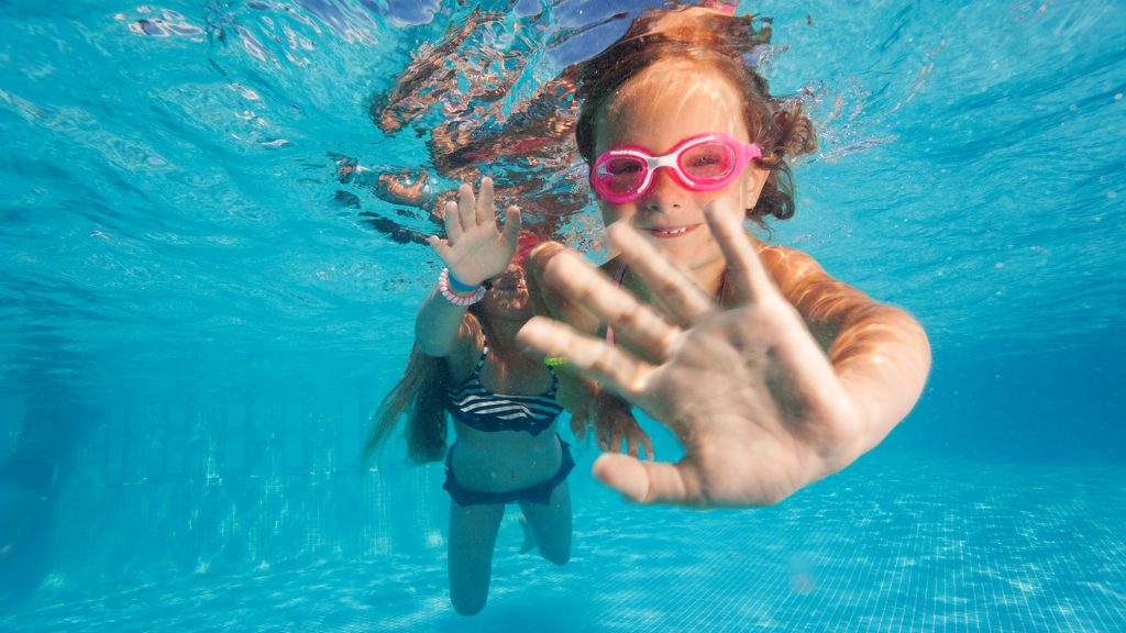 Två flickor dyker i en pool