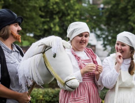 Tre utklädda personer under en föreställning utomhus