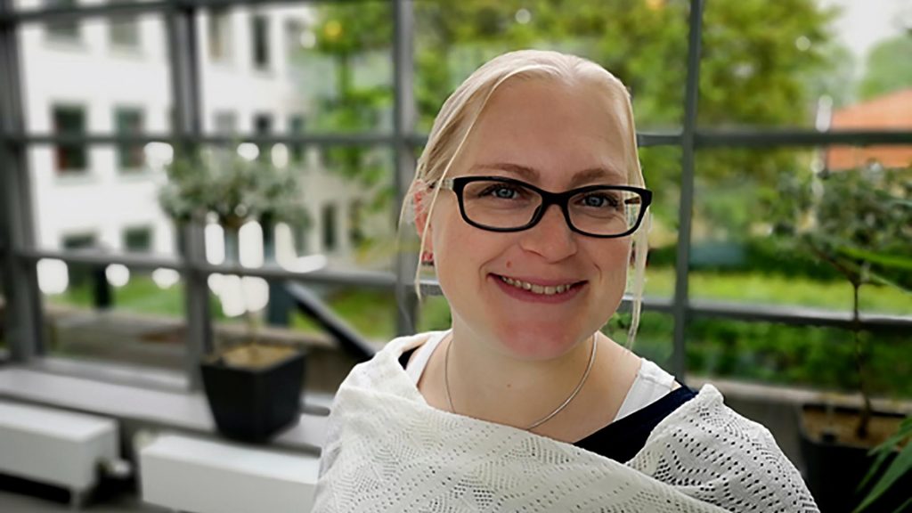 Porträtt på en kblond kvinna med svarta glasögon.