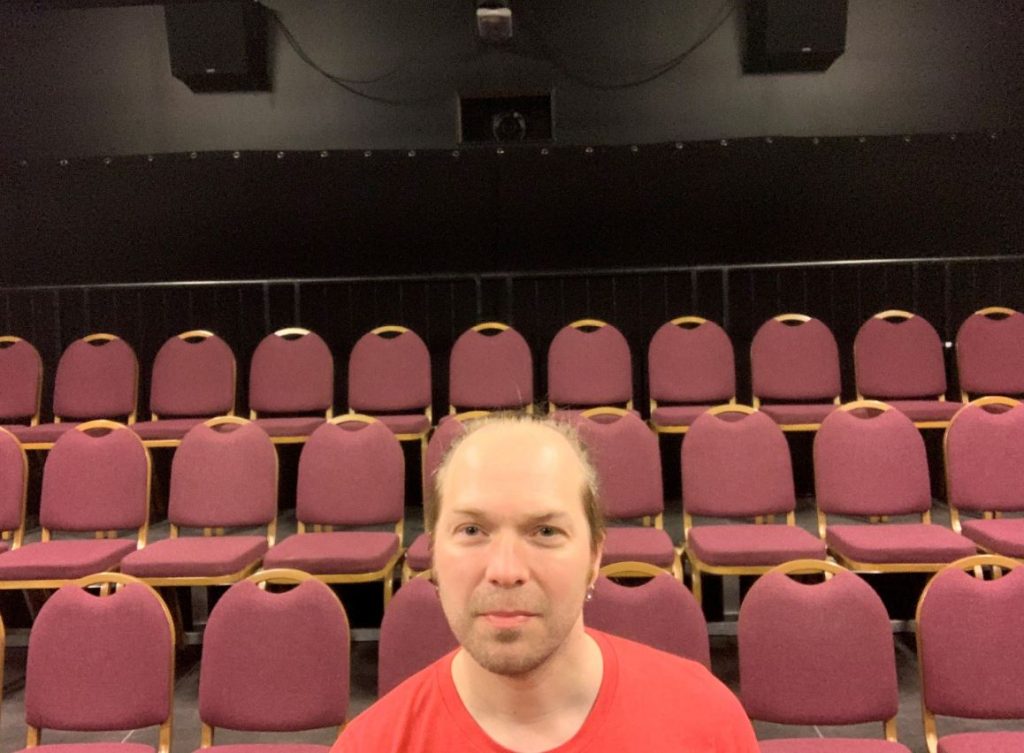 Roger framför röda stolar
