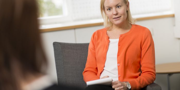 Kvinna sitter i mötesrum.