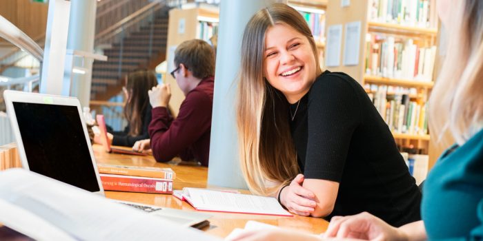 Samtal mellan studenter på Högskolans bibliotek