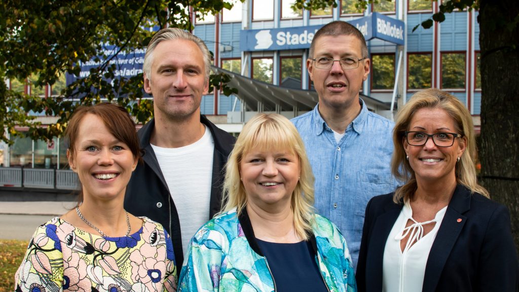 Fem politiker från majoriteten i kommunfullmäktige står framför stadsbiblioteket i Gävle