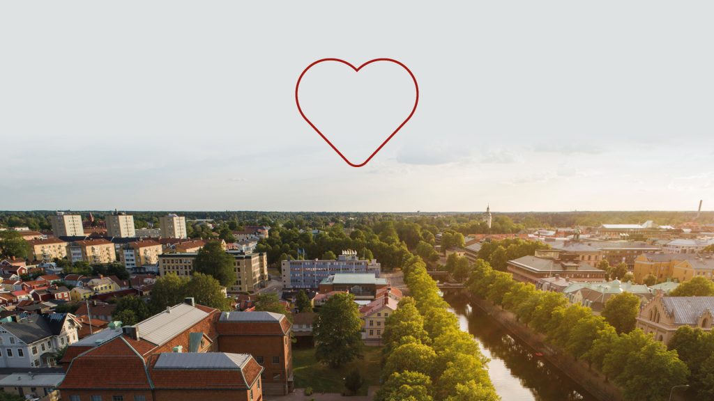 Flygbild över Gävle med ett rött illustrerat hjärta i himlen.