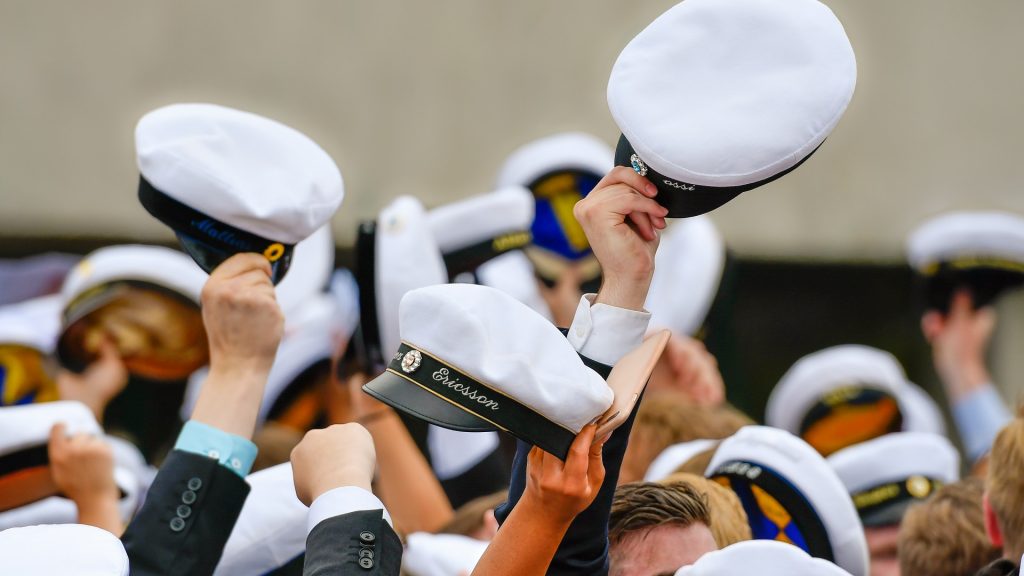 Studenter med studentmössor i handen