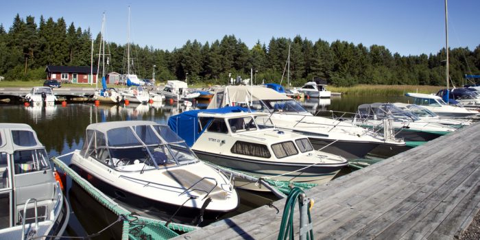 Båtar parkerade på båtplatser vid brygga