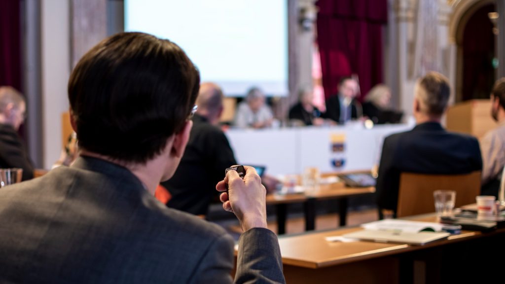 Politiker röstar i kommunfullmäktige.