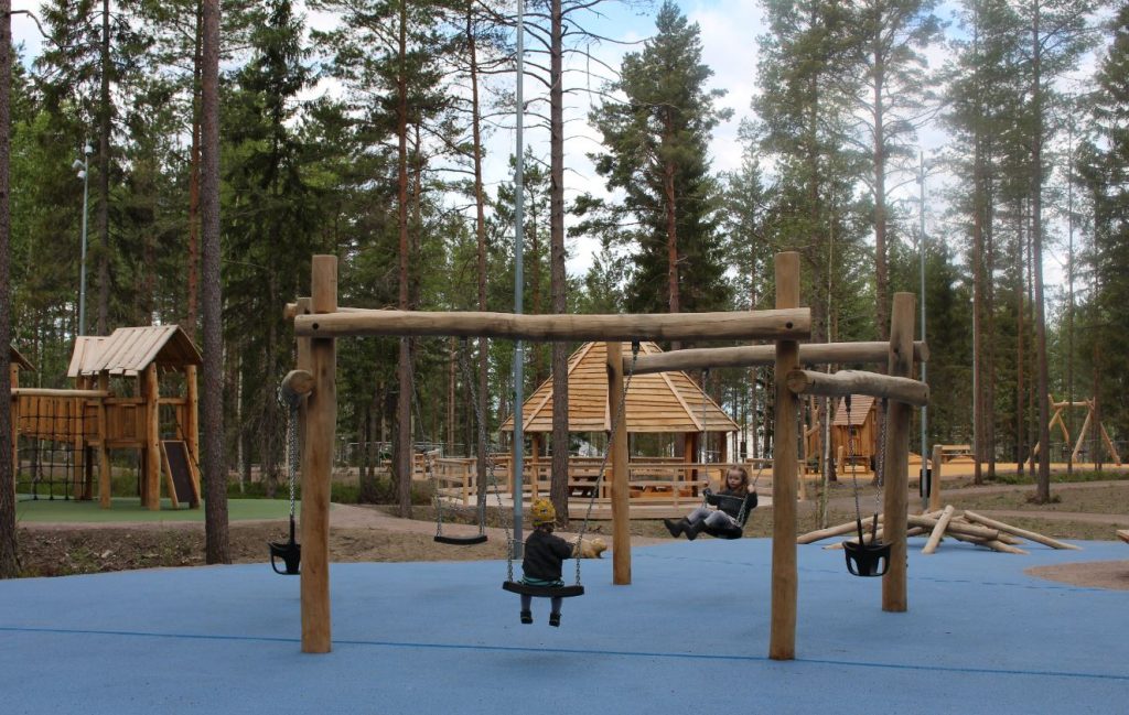 Lekpark i skogen gjord av träd.