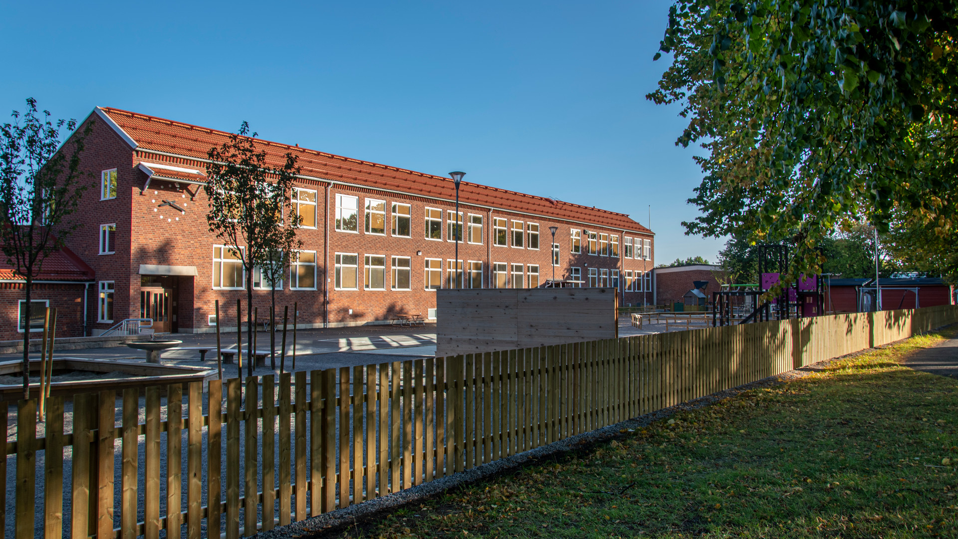 Exteriörbild på Solängsskolan med skolgården i förgrunden