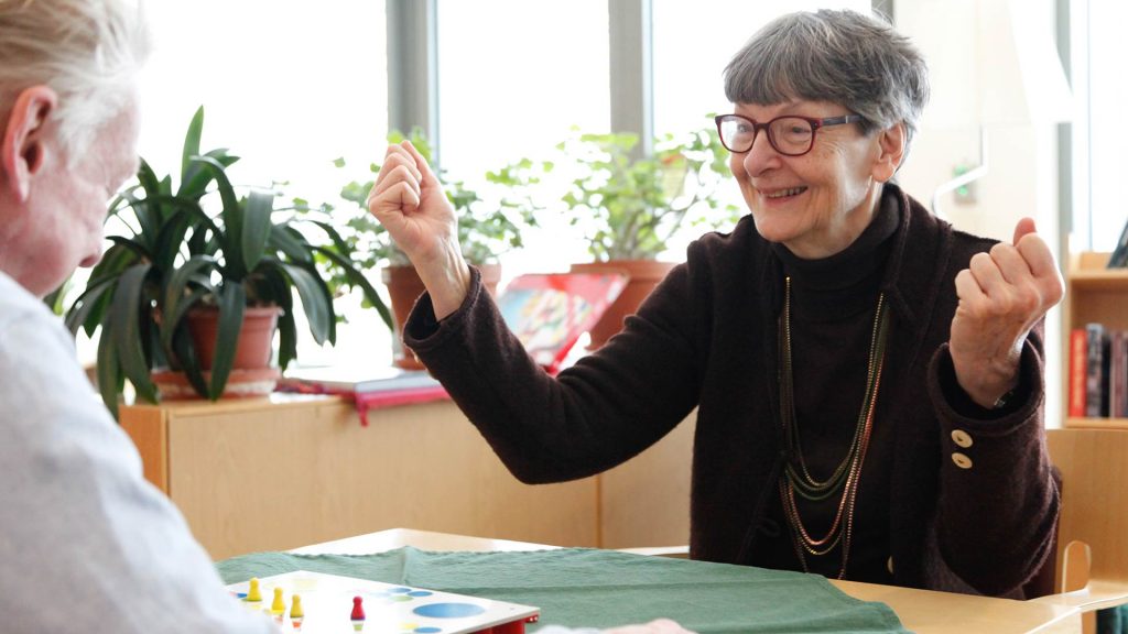 Två pensionärer sitter och spelar brädspelet Fia med knuff