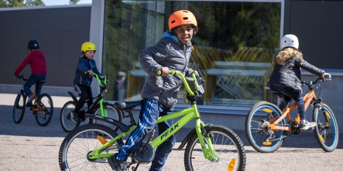Fyra barn som cyklar på en grusplan