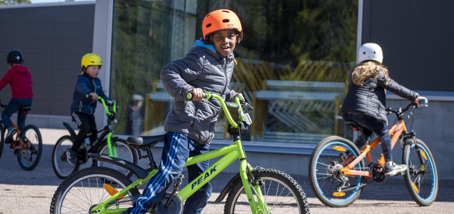Fyra barn som cyklar på en gårdsplan