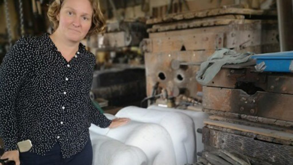 En kvinna står vid konstverket Stapelsaden