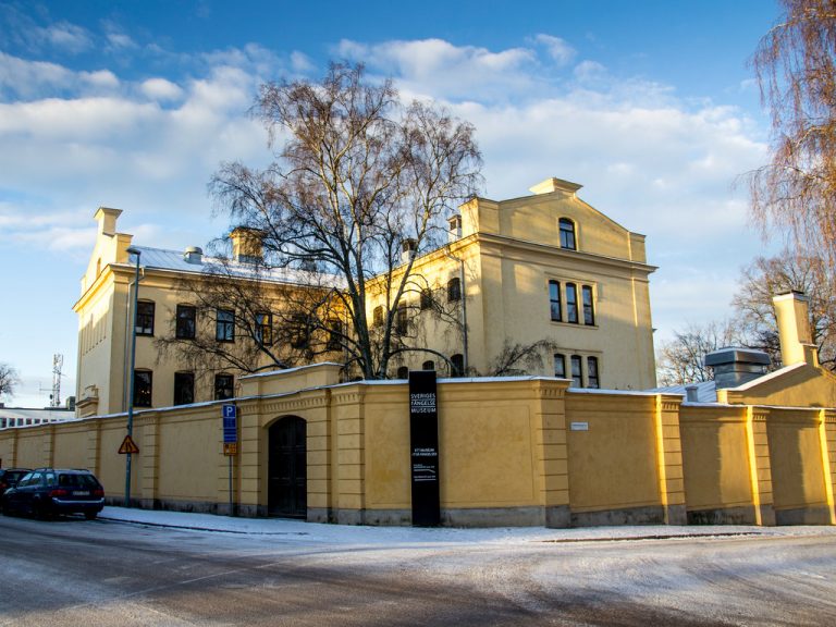 Gävle fängelsemuseum lyses upp av solen en solig vinterdag. Lite snö syns på asfalten