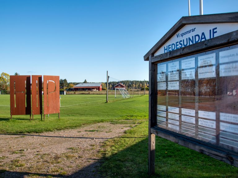 Hedesunda idrottsplats med skylt på Hedesundas sponsorer