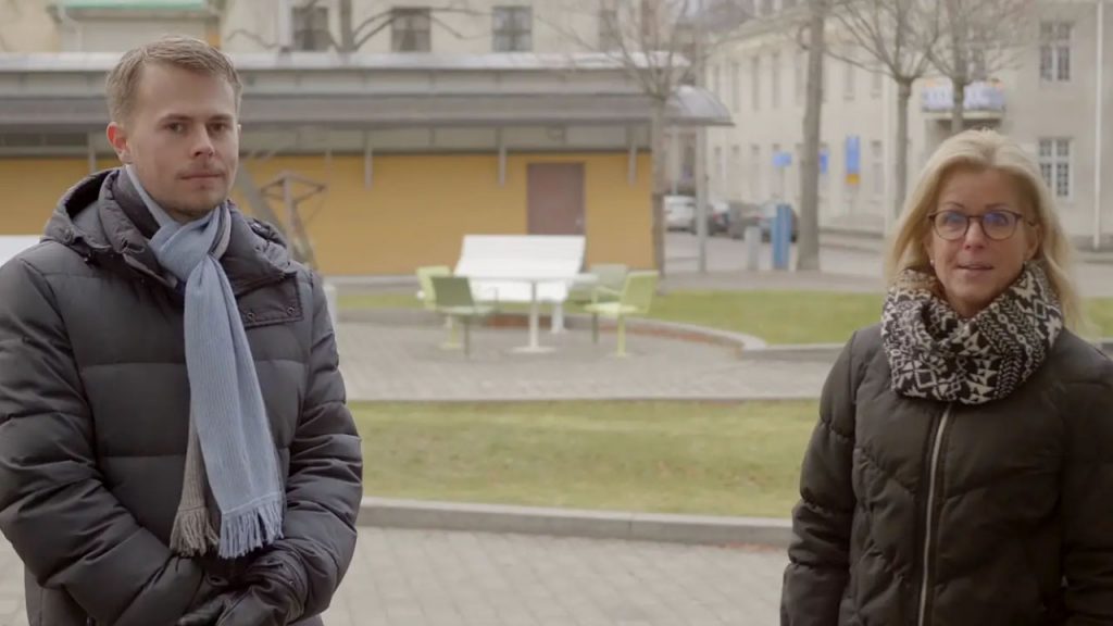 En man och en kvinna stående ute i ytterkläder på Stadshusets innergård.
