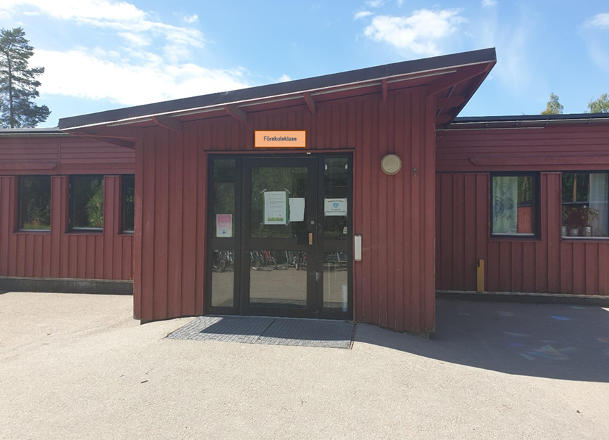 Entré till förskola med röd fasad.
