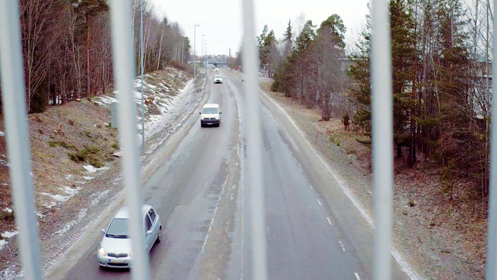Vy från cykelbro ner mot bilväg.