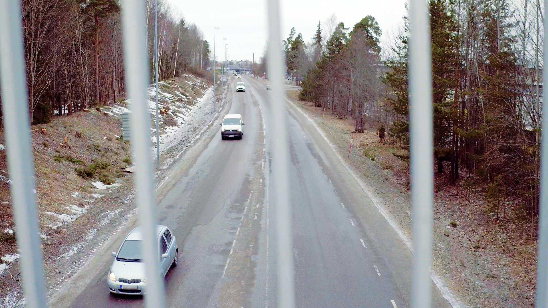 Vy från cykelbro ner mot bilväg.