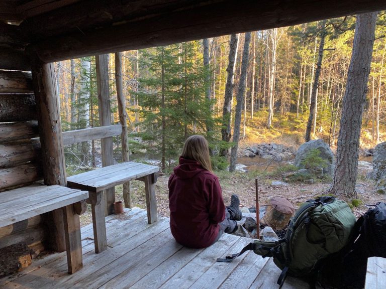 Kvinna sitter i vindskydd vid Skärjåns naturreservat