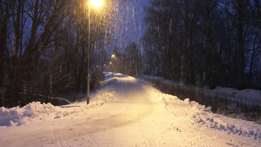 Cykelbana täckt i snö en snöig kväll.