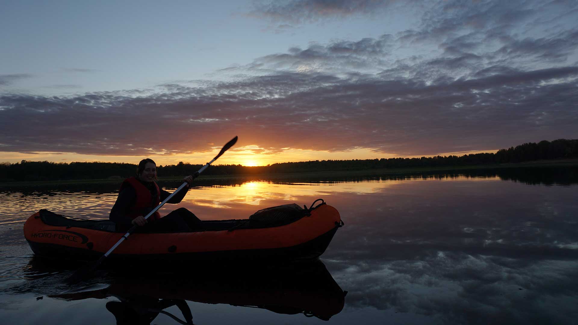 Paddling i havet i solnedgång.