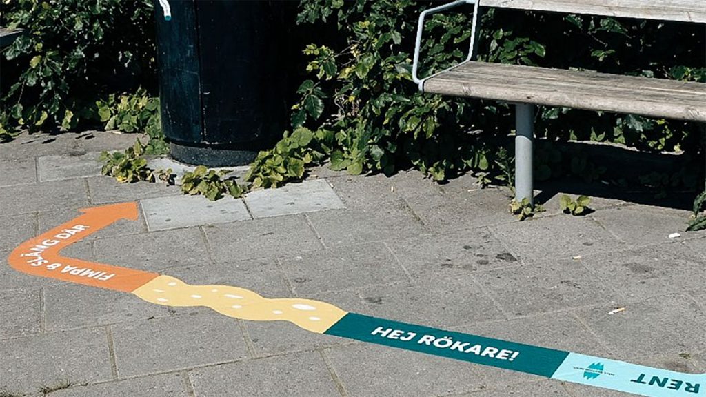 Dekal placerad i anslutning till en offentlig sopkorg.