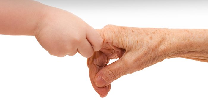Äldre hand och barnhand håller varandra.