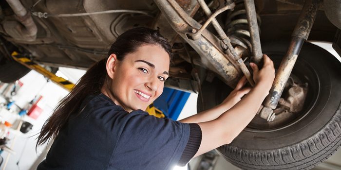 Porträtt på en leende ung kvinnlig mekaniker.