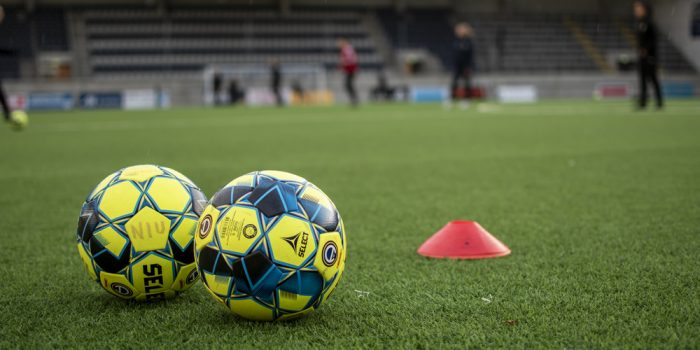 Närbild på fotbollar på fotbollsplan.
