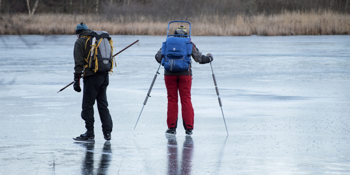 Par som åker långfärdsskridskor på is utomhus.