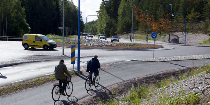 Två personer som cyklar bredvid en rondell