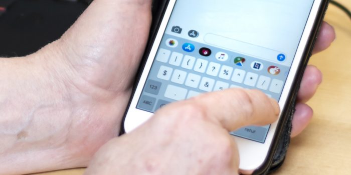 En hand skriver på en mobiltelefon