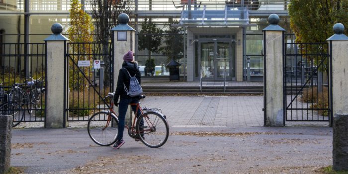 Perosn med cykel stående utanför högskolan i Gävle