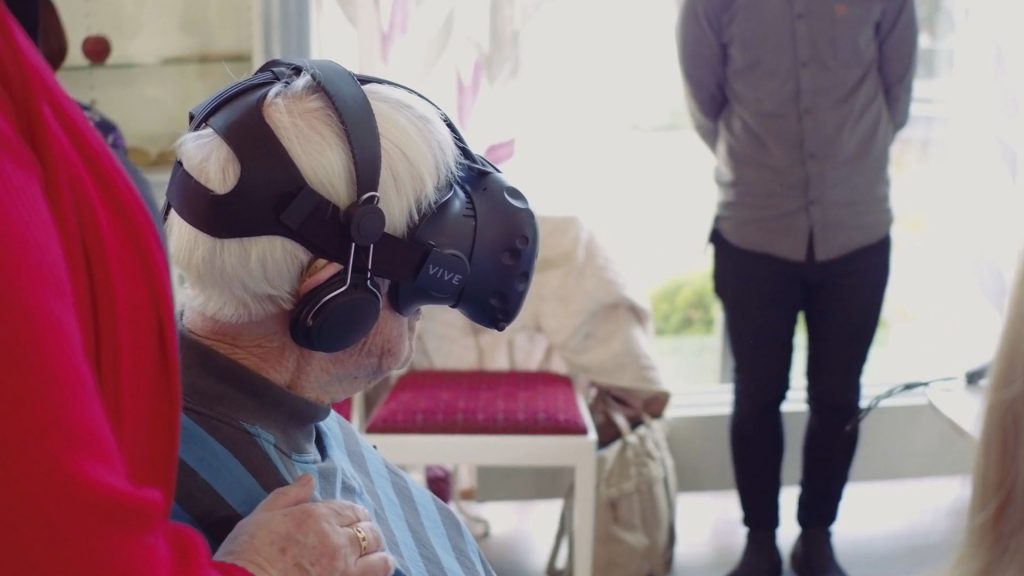 En äldre person som testar VR