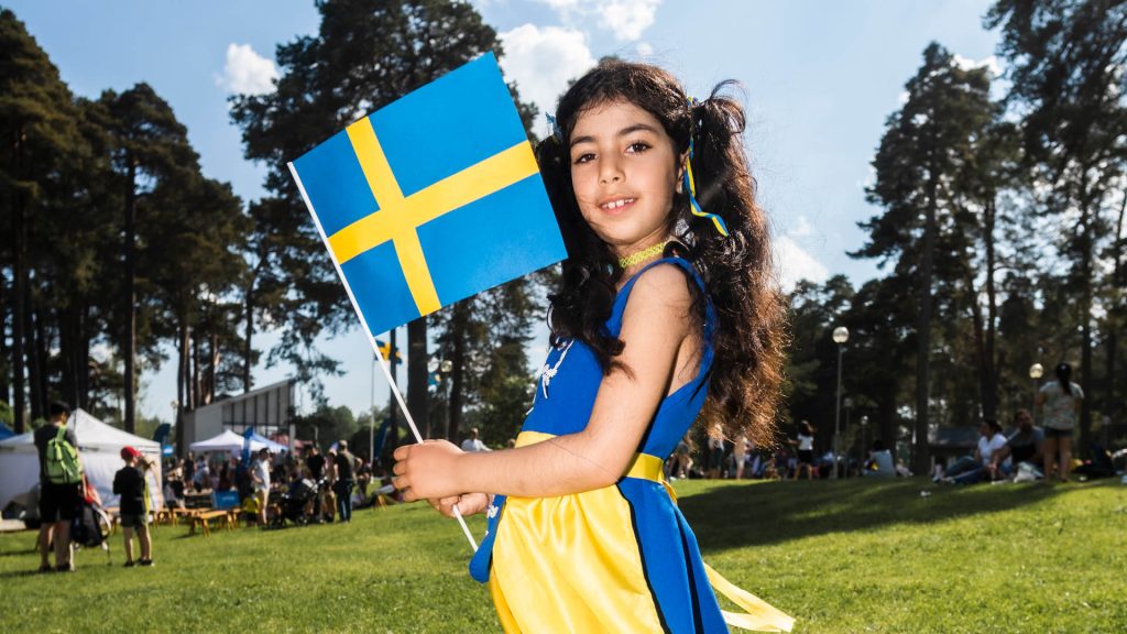 Flicka som håller i svenska flaggan .