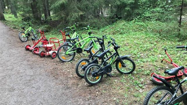 Cyklar till MTX-banan som står på rad längs skogsvägen.