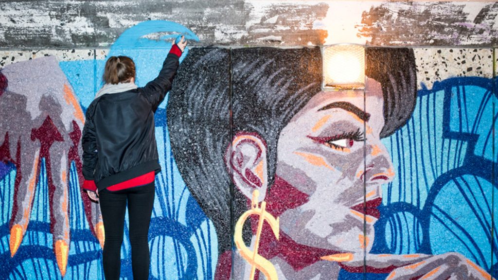 Person som målar grafitti på en vägg